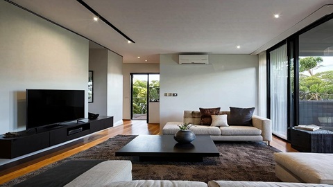 Professional AC technician installing ducted air conditioning system in modern Australian home